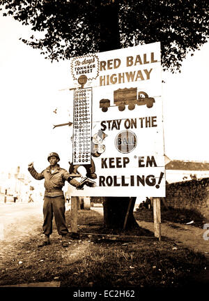 Corporal Charles H. Johnson of the 783rd Military Police Battalion, waves on a 'Red Ball Express' motor convoy rushing priority materiel to the forward areas, near Alencon, France.  September 5, 1944.  Bowen.  (Army) Stock Photo