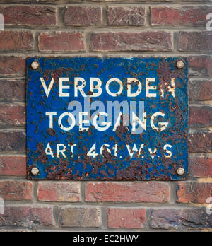 Rusty old plate on brick wall with Dutch text 'No Trespassing' Stock Photo