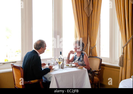 An older couple having dinner together in a hotel restaurant in England Stock Photo