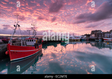 Beautiful sunrise over fishing boats in the harbour at Padstow in Cornwall Stock Photo