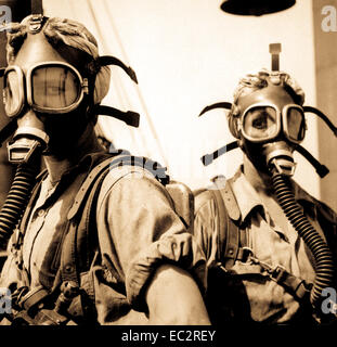 Like girls from Mars are these 'top women' at U.S. Steel's Gary, Indiana, Works.  Their job is to clean up at regular intervals around the tops of twelve blast furances.  As a safety precaution, the girls wear oxygen masks.  U.S. Steel Corp.  (Women's Bureau) Stock Photo