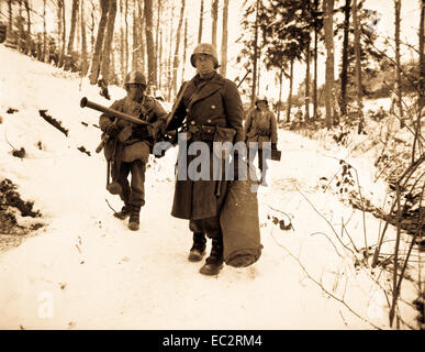 After holding a woodland position all night near Wiltz, Luxembourg, against German counter attack, three men of B Co., 101st Engineers, emerge for a rest.  January 14, 1945.  Gilbert. (Army) Stock Photo