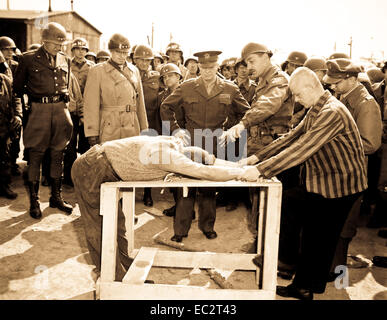 Gen. Dwight D. Eisenhower watches grimly while occupants of a German concentration camp at Gotha demonstrate how they were tortured by the Nazi sadists operating the camp.  Generals Bradley and Patton are at his right.  Germany, April 12, 1945.  Lt. Moore.  (Army) Stock Photo