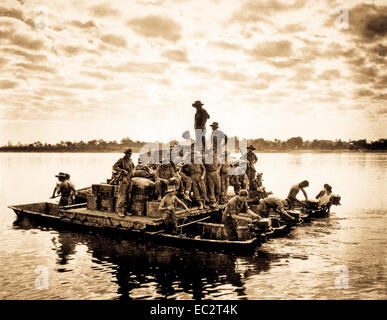 A barge, powered by outboard motors, crosses the Irrawaddy River near Tigyiang, Burma.  The men, their truck and ammunition all make the crossing at once in this way.  December 30, 1944.  Sgt. William Lentz.  (Army) Stock Photo