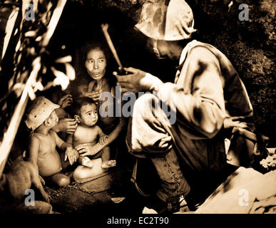 A member of a Marine patrol on Saipan found this family of Japanese hiding in a hillside cave.  The mother, four children and a dog, took shelter from the fierce fighting in that area.  June 21, 1944. Stock Photo