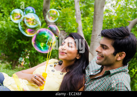 2 indian couple park playing Bubble Wand Stock Photo