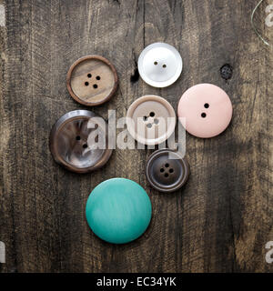 Collection of various buttons on old wooden table Stock Photo