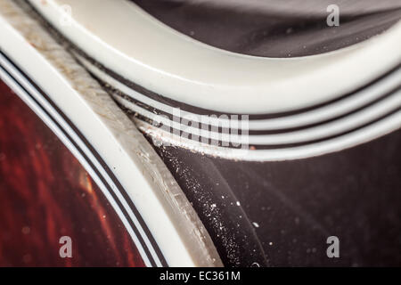 Materials of a guitar, plastic part meets black wooden body part. Stock Photo