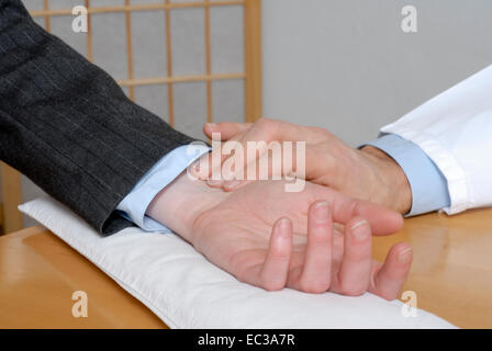 Doctor Testing Pulse of a Patient Stock Photo