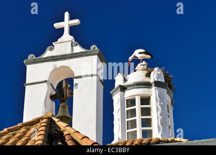 Portugal, Algarve: Stork nest  with two white storks on the top of Igreja Pé da Cruz in Faro