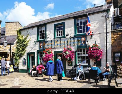 Tourists sitting at a pavement cafe outside the Bakewell pudding factory in the town centre, Bakewell, Derbyshire, England, UK, Stock Photo