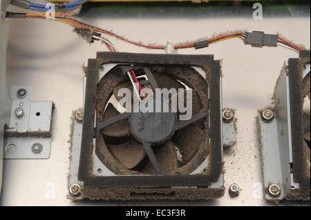 Dust accumulation inside electronic equipment showing cooling fan clogged with dirt Stock Photo