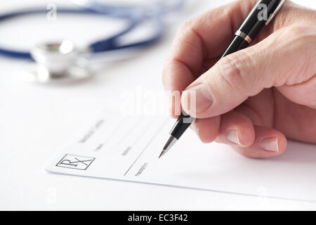 Doctor is writing a prescription in the consulting room. Stock Photo