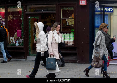 London, UK. 9th December 2014. Snow flakes start to fall on shoppers as the first signs of snow appears in Oxford Street Credit:  amer ghazzal/Alamy Live News Stock Photo