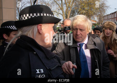 Ealing, London, UK. 9th December 2014. Mayor of London Boris Johnson visits Ealing accompanied by Met Police Commissioner Sir Bernard Hogan-Howe hold a walkabout in Ealing to announce details of the historic deal secured for the New Scotland Yard site in Victoria. PICTURED: Boris Johnson talks with a police officer outside Ealing Broadway station. Credit:  Paul Davey/Alamy Live News Stock Photo