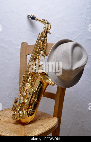 saxophone on a chair with a hat Stock Photo