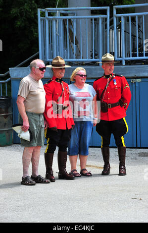 Mounted police pose with members of the public at Canada Day celebrations held in a park in London, Ontario. Stock Photo