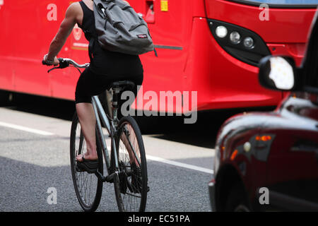 A female cycling in London traffic Stock Photo