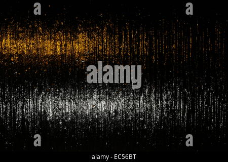 Obscured window abstract with black, gold and silver taken at night time with the street lights shining through the textured glass Stock Photo
