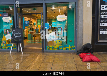 EE mobile phone shop with homeless beggar outside on Princes Street Edinburgh Scotland UK Stock Photo