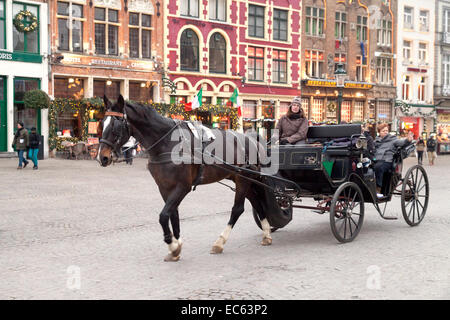 Tourists on a horse and carriage tour of Bruges in winter, Belgium, Europe Stock Photo