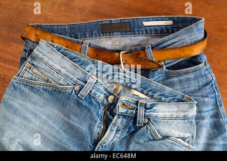 Two pair of blue jeans on a wood surface Stock Photo