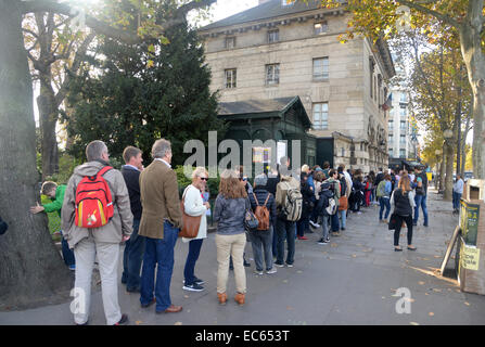 Tourists queue up to 3 hours to enter the Paris Catacombs, the vast ossuary beneath the city streets at Place Denfert-Rochereau Stock Photo