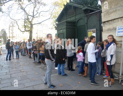 Tourists queue up to 3 hours to enter the Paris Catacombs, the vast ossuary beneath the city streets at Place Denfert-Rochereau Stock Photo