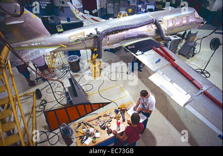 Workers and aviation mechanics assemble a corporate jet aircraft. Stock Photo