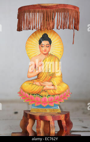 Small Buddhist carving sitting in lotus position at temple Stock Photo