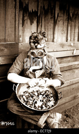 World War One soldiers try out their gas masks in every possible way.  Putting the respirator to good use while peeling onions.  40th Division, Camp Kearny, San Diego, California  March 1918. Stock Photo