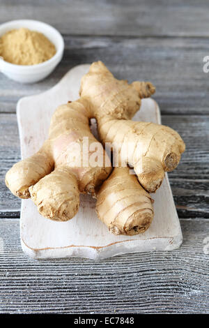Spicy ginger on a cutting board on wooden background Stock Photo