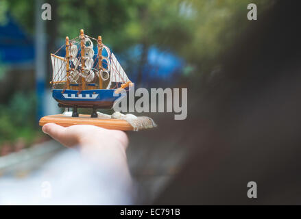 Hand holding model of a sailing ship Stock Photo