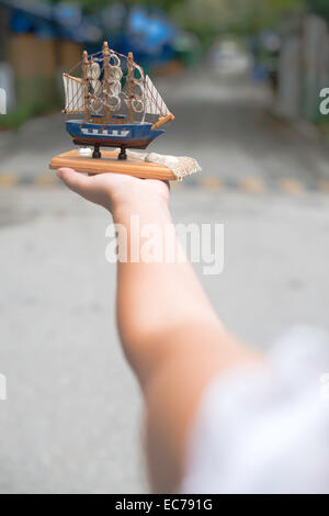 Hand holding model of a sailing ship Stock Photo
