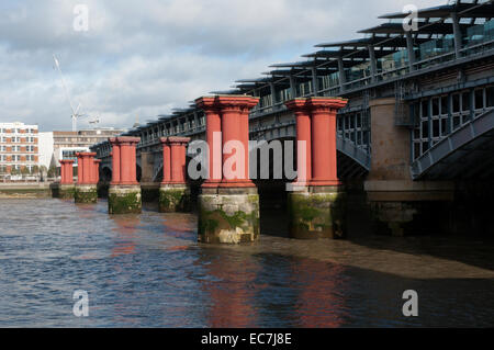 Pillars of the old Blackfriars Bridge across the River Thames, next to the existing railway bridge and Blackfriars Station. Stock Photo
