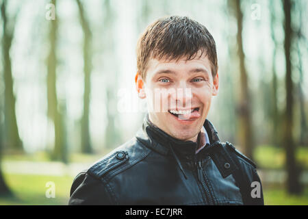 Close Up Young Handsome Man Shows Tongue. Outdoors Portrait. Spring Colours. Stock Photo