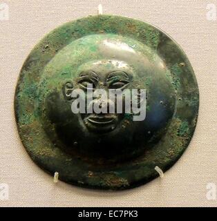 Left: Bronze circular fitting (From a shield or harness), depicting a human face. Western Zhou period, Chinese, 11-10th century BC Stock Photo