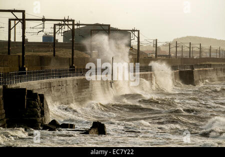 Waves as they crash over the promenade wall on December 10, 2014 in Saltcoats, Scotland. Stock Photo