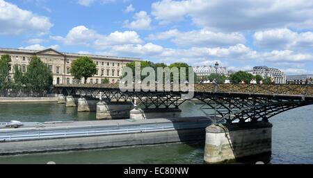Photograph of the Pont des Arts a pedestrian bridge in Paris which crosses the River Seine. Attached to the fencing of the bridge are Love-Locks, padlocks which sweethearts lock to a bridge, fence, gate, or similar public fixture to symbolize their love. Dated 2014 Stock Photo