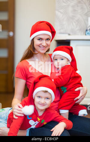 Mother with kids, baby Santas helpers. Merry Christmas and New Year concept Stock Photo
