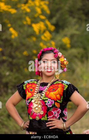 A traditional costumed young woman folk dancer wearing a Zapotec embroidered dress poses during the Day of the Dead Festival known in spanish as D’a de Muertos on October 29, 2014 in Oaxaca, Mexico. Stock Photo