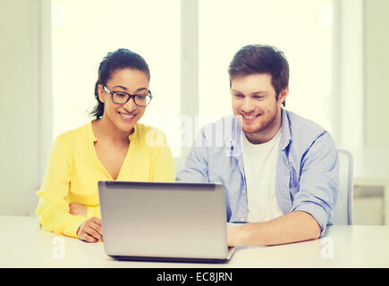two smiling people with laptop in office Stock Photo