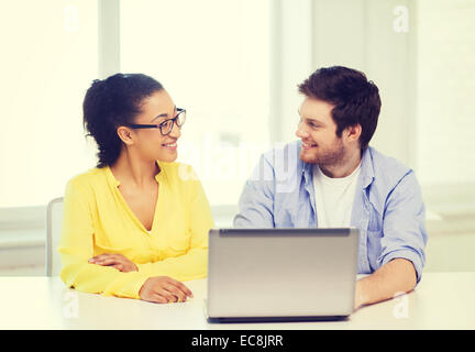 two smiling people with laptop in office Stock Photo