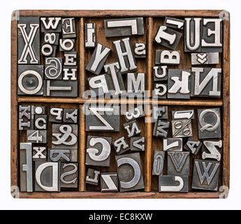 alphabet and other symbols in old metal type printing blocks in a rustic wooden typesetter box Stock Photo