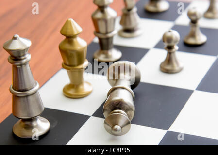 Classic chess game - fallen silver king on chessboard Stock Photo
