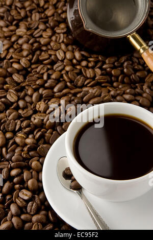 cup of coffee and copper pot on beans Stock Photo