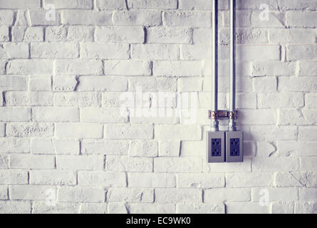 Electrical Socket on a White Painted Brick Wall Stock Photo