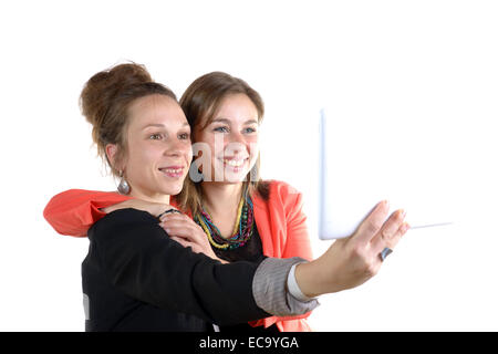 two pretty teen girls taking selfies with her digital tablet on white Stock Photo
