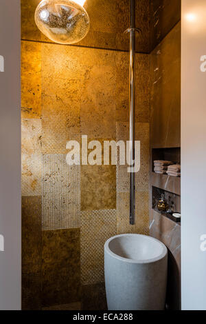 Powder room with gold ceramic tiles, granite pedestal sink and ceiling suspended faucet Stock Photo