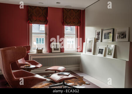 Pair of red leather lounge chairs from Moroso in study with red paisley wool drapes Stock Photo